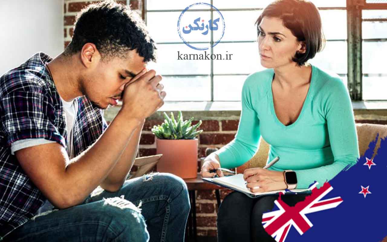 بازار کار روانشناسی در خارج از کشور (نیوزلند)، یک روانشناس زن در حال مشاوره دادن به یک مرد جوان ناراحت به همراه پرچم نیوزلند
