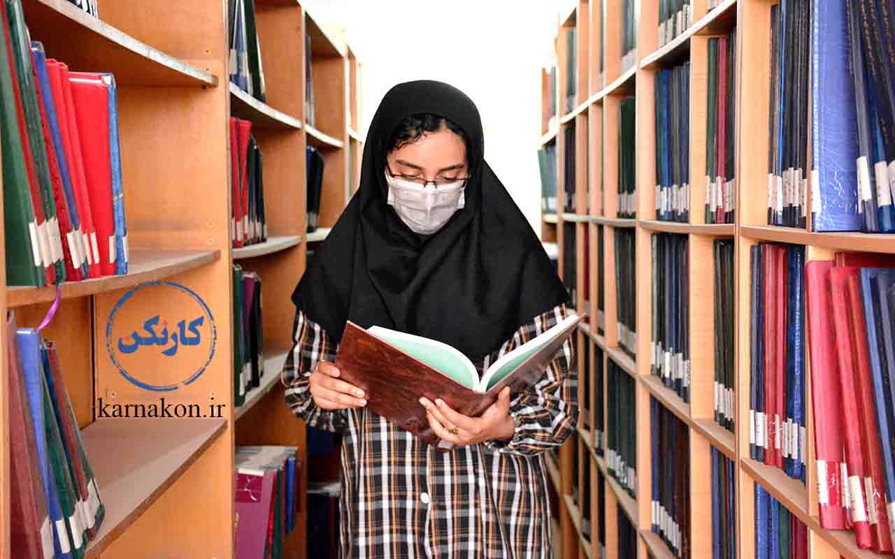 دانشجوی دختر در حال مطالعه در کتابخانه یکی از دانشگاه های غیر انتفاعی